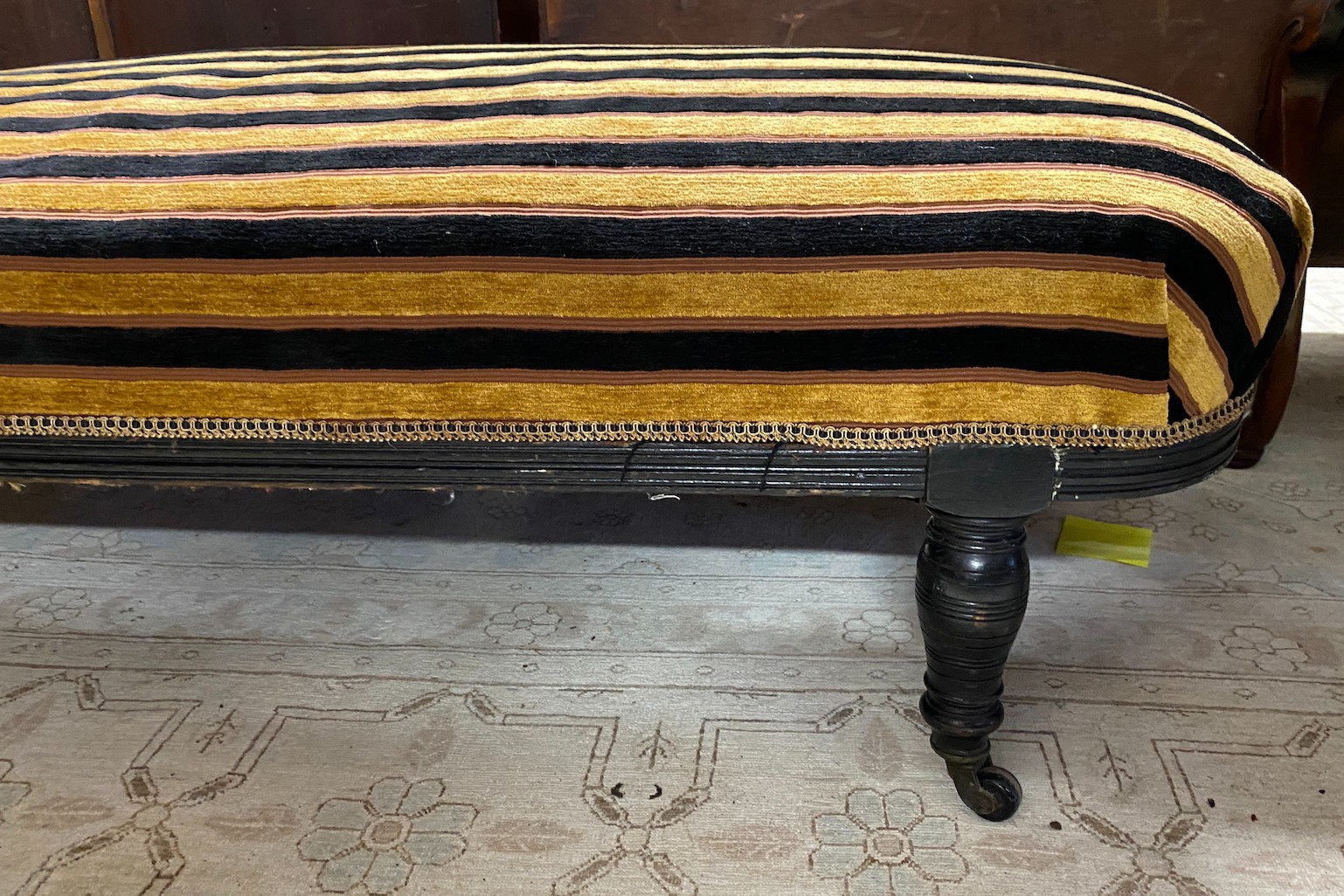 An Aesthetic period ebonised chaise longue, in the manner of E. W. Godwin, length 164cms, depth 61cms, height 75cms.